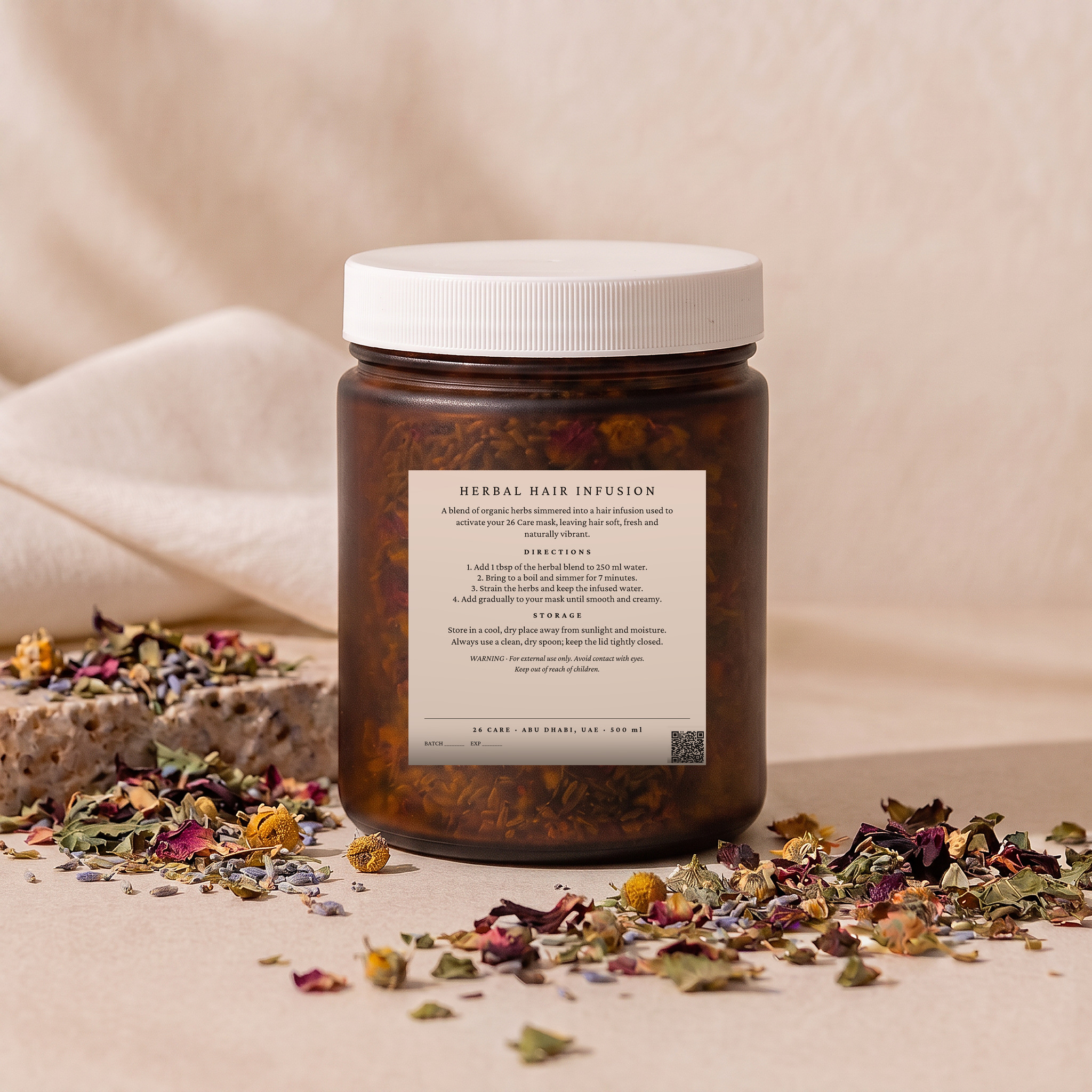26 Care Herbal Hair Infusion in a frosted amber jar with cream label and loose dried botanicals beside it — Back — directions & warnings